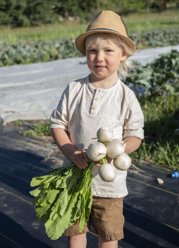 boy at cartwheel farms holding vegetables