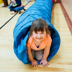 Little kid playing in small tunnel.
